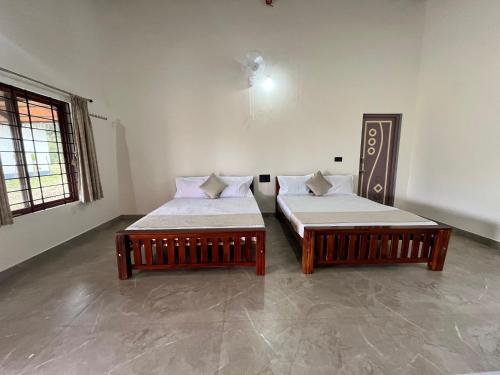 two beds sitting in a room with at Kavalubare Retreat by Dazzle Destinations - Private Cottages and Near to City in Chikmagalūr
