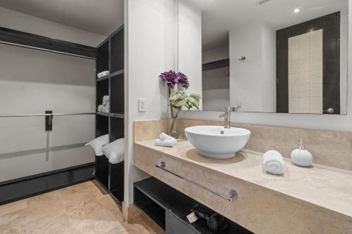a bathroom with a sink and a large mirror at Deck12 Casino and Resort by Monyxbnb in Puerto Vallarta