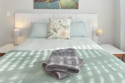 a bed with two towels sitting on top of it at Hugo Haven in Bredasdorp