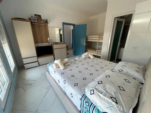 a bedroom with a large bed with white sheets at Villa 6C Sunny Nest in Draçi