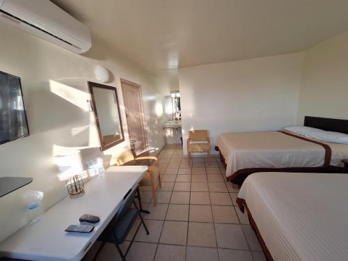 a small hotel room with two beds and a desk at #36 Bungalow Seaside Hotel & Victors RV Park in San Felipe