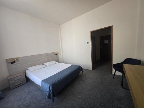 a bedroom with a bed and a desk and a chair at Hotel Astoria City Center in Iaşi