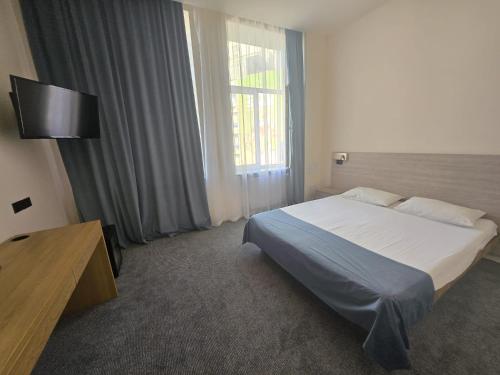 a hotel room with a bed and a window at Hotel Astoria City Center in Iaşi