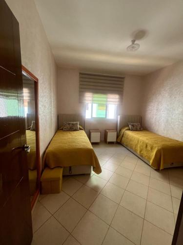 una camera da letto con due letti e una finestra di appartement Anna 2 chambres et salon balcons de avec piscine bien situé au centre de oued laou a Oued Laou