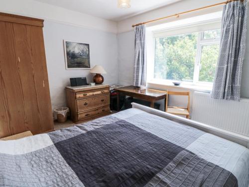 a bedroom with a bed and a desk and a window at Low Muffles Bridge in Pickering