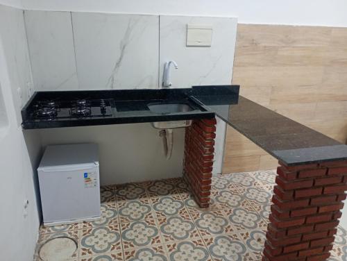 a kitchen with a sink and a brick counter at Hospedaria Km 20 da Br 040 Luziânia in Luziânia