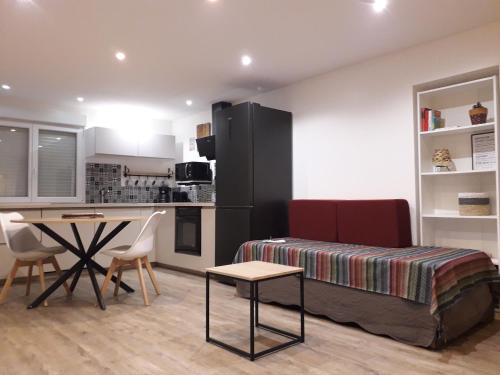 a bedroom with a bed and a table and a kitchen at Villa Pillapi in Céret