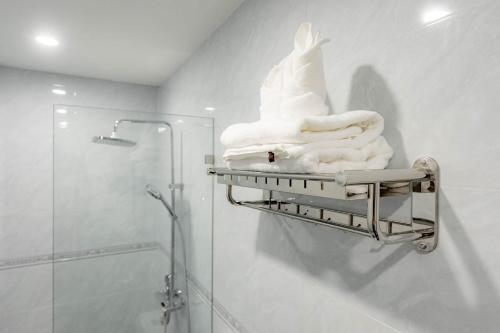 a towel rack with towels on it in a bathroom at Cozy An Luangprabang Hotel in Luang Prabang