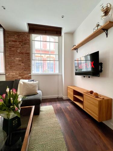 a living room with a couch and a tv at Cosy 2 Bed Retreat with FREE Secure Parking in Nottingham