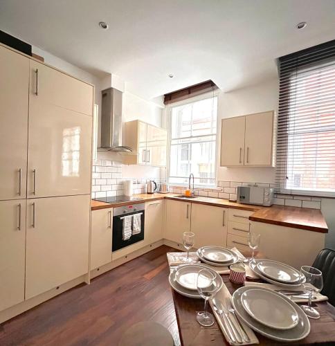 a kitchen with a table with plates on it at Cosy 2 Bed Retreat with FREE Secure Parking in Nottingham