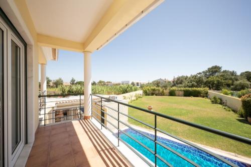 a balcony of a house with a swimming pool at São Pedro do Estoril Villa By Hosty in Parede