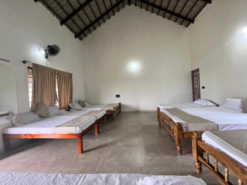 a row of beds in a room at Kavalubare Retreat by Dazzle Destinations - Private Cottages and Near to City in Chikmagalūr