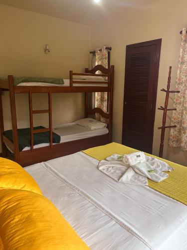 a bedroom with two bunk beds and a yellow bedspread at Pousada Sanhaço in Abraão