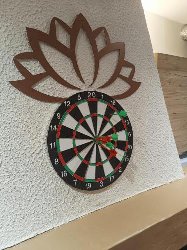 a dart board on a wall with a flower on it at Escale Secrète Détente Montargis Parking Gratuit in Montargis