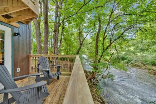 a wooden deck with two chairs and a river at Creekwalk Inn Bed and Breakfast with Cabins in Cosby