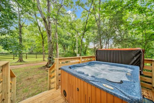a hot tub sitting on a deck with a chair at Creekwalk Inn Bed and Breakfast with Cabins in Cosby