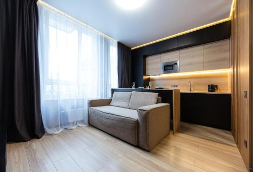 a living room with a chair and a kitchen at Nyvky Like Home - Файна Таун з басейном - Кв 3 in Kyiv