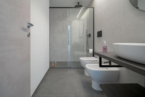 a bathroom with two toilets and a sink and a shower at Room 52 - stanza da sogno in Biella