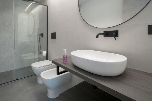 a bathroom with a sink and a toilet and a mirror at Room 52 - stanza da sogno in Biella