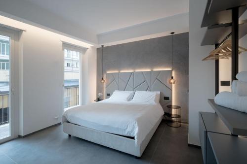 a bedroom with a white bed and a large window at Room 52 - stanza da sogno in Biella