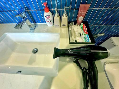 a bathroom sink with a hair dryer next to it at ICON40 Ha Long Luxury Apart in Ha Long