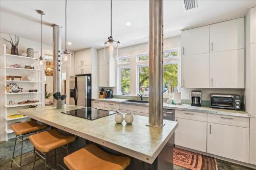 a kitchen with white cabinets and a large island with bar stools at LunaSea by 30A Escapes in Seagrove Beach