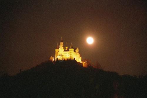 a castle on a hill at night with the moon at 3 Sterne Gästehaus Zollerblick in Zimmern