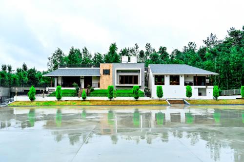 a house with a lot of water in front of it at Villa Vaasa Luxury Homestay in Avathi