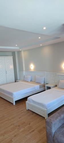 a room with three beds and a couch at Hotel BLADOR in Tichi