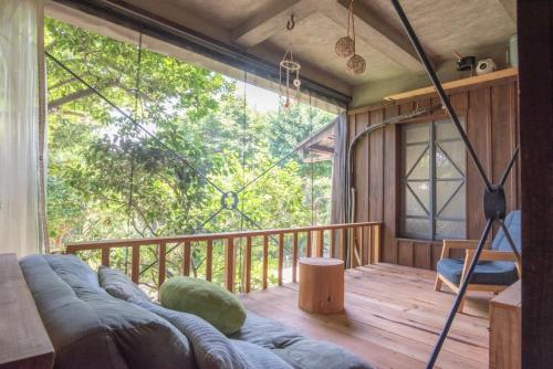 a living room with a couch on a deck at 伊勢ゲストハウス紬舎-Ise Guesthouse Tsumugiya- in Ise