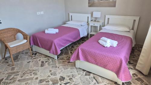 two beds in a room with purple sheets at Angolo del Mare - Case Libeccio e Blu Marino in Favignana