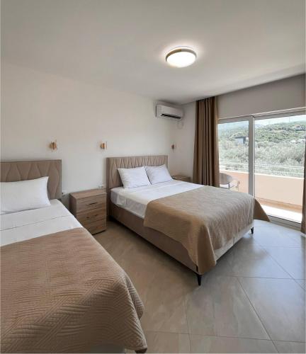 a hotel room with two beds and a window at Apartments Aura in Utjeha