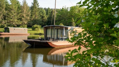 a boat sitting on the water in a lake at Le Village des Monédières in Chamberet
