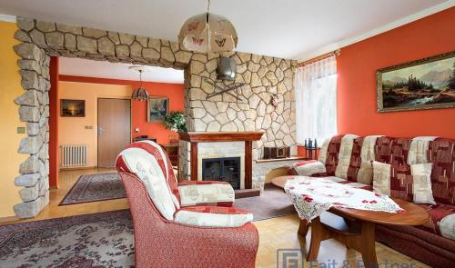 a living room with red walls and a stone fireplace at Pension Doris in Velká Hleďsebe