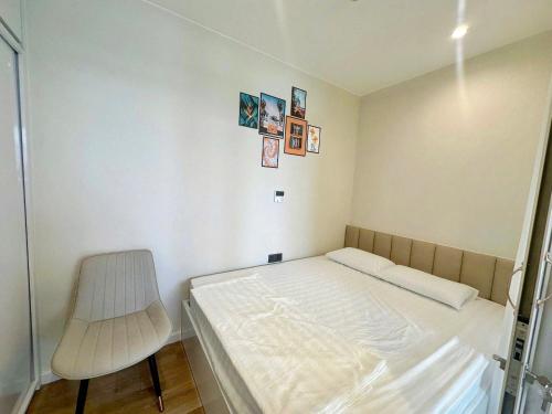 a small bedroom with a bed and a chair at ICON40 Ha Long Luxury Apart in Ha Long
