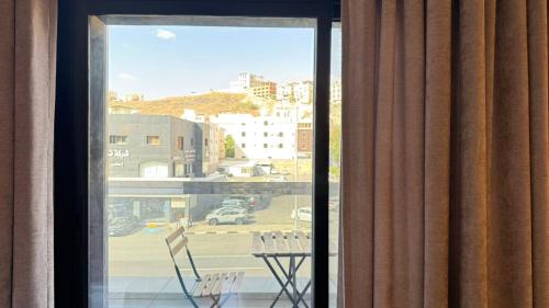 a room with a window with a table and chairs at Le Reve Hotel إحدى فنادق مجموعة لوريف By Le Reve Company in Taif