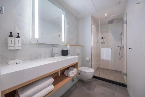 a bathroom with a sink and a toilet and a shower at Crowne Plaza Utrecht - Central Station by IHG in Utrecht