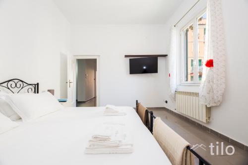 a white bedroom with two beds and a window at Airport 8 Minutes, 2BR, Terrace, By Tilo in Genova