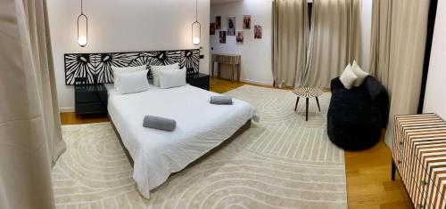 a bedroom with a large white bed with two pillows at Villa Octagon Essaouira in Essaouira
