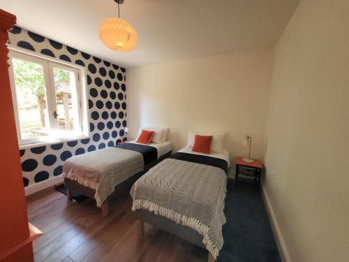 deux lits dans une chambre à pois bleus et blancs dans l'établissement Maison du Morilhou, à Auriac-du-Périgord