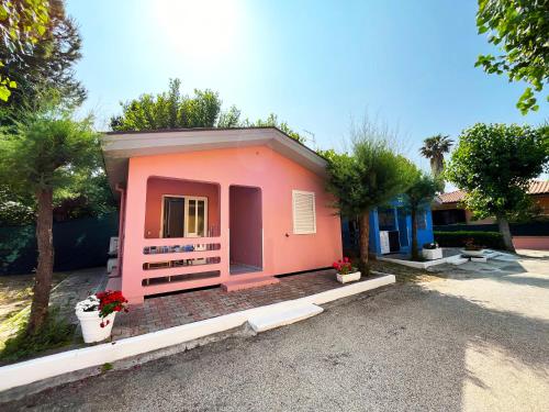 a small pink house with trees and plants at JuliaMare Village in Giulianova