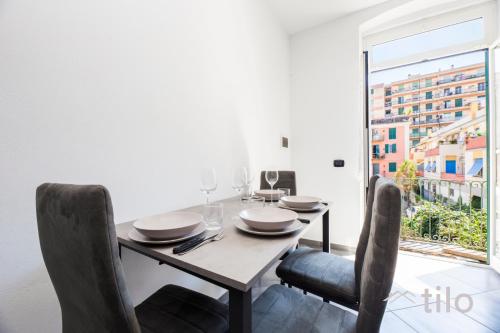 a dining room with a table and chairs and a window at Airport 8 Minutes, 2BR, Terrace, By Tilo in Genova