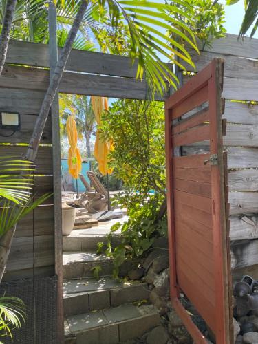 an entrance to a garden with a wooden door at Villa Albizia 974 avec piscine et spa in Saint-Pierre