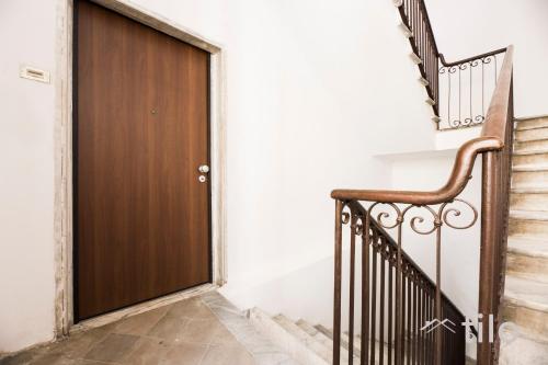 a wooden door in a hallway with stairs at Airport 8 Minutes, 2BR, Terrace, By Tilo in Genova