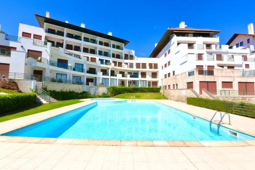 an empty swimming pool in front of a building at Ocean - Duplex apartment 65m from the beach with pool and parking in São Martinho do Porto