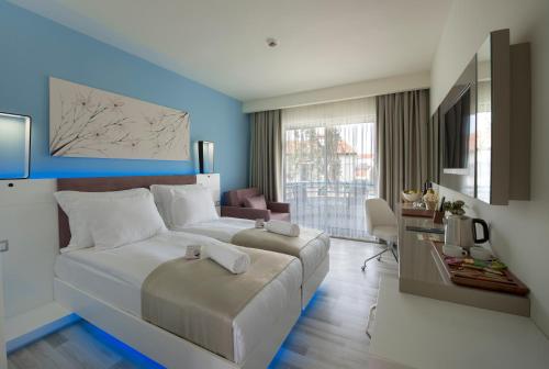a bedroom with a large bed and a living room at Flora Garden Ephesus Kusadasi - All Inclusive in Davutlar