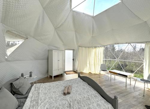 a bedroom with a large bed and a large window at Bubble House glamping telk in Sõmeru