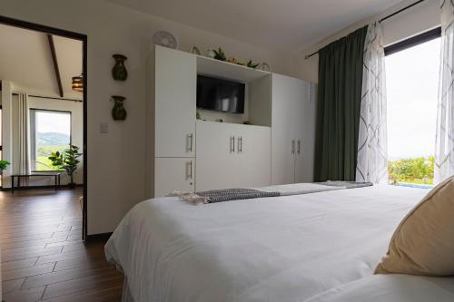 a bedroom with two beds and a large window at La Vista in Piedras