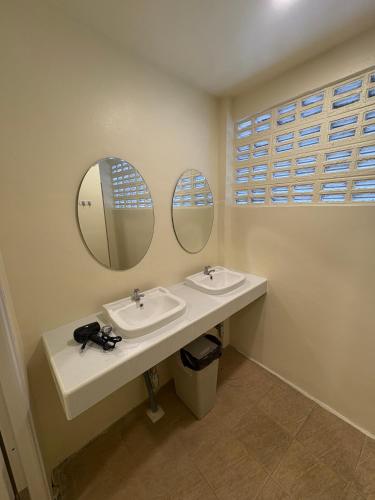 a bathroom with two sinks and two mirrors at Nomad Yard Hostel in Bangkok