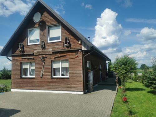 una casa di legno con tetto a padiglione di Edmart a Dobromislė